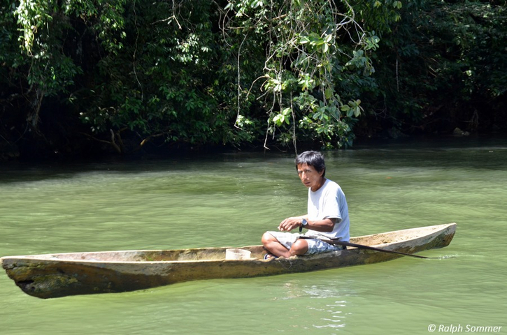 Indigener mit Einbaumboot